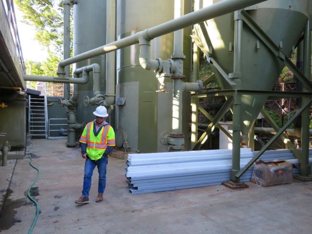 Worker standing next to sand filter.