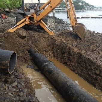 Excavator working on a sewer pipeline.
